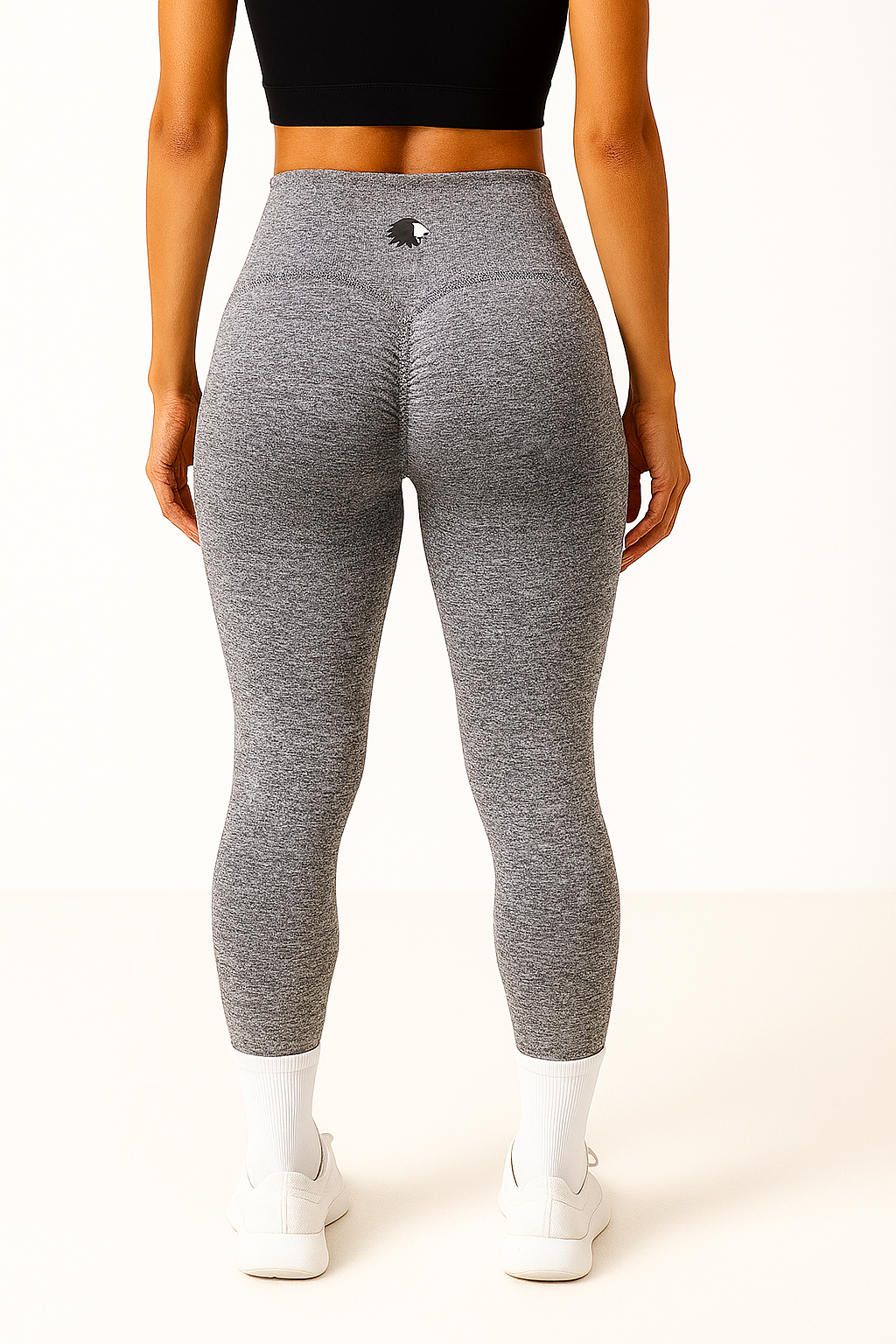 Person wearing gray leggings with a logo on a white background